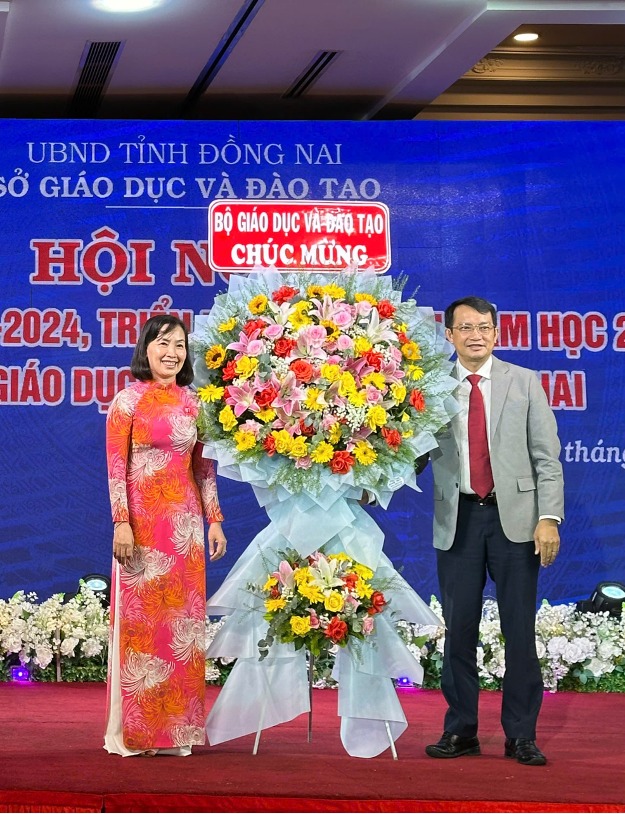 Ông Lê Thắng Lợi, Đại diện Văn phòng Bộ, Phó Giám đốc phụ trách Trung tâm phát triển GDĐT phía Nam tặng hoa chúc mừng Hội nghị.